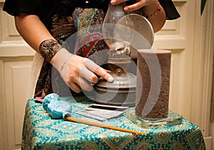 Gypsy fortune girl stands near the table with magical attributes: candles, cards, bahurs and etc