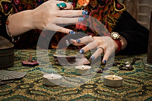 Gypsy psychic looking for a man in a photo using a pendulum. Love spell on photos