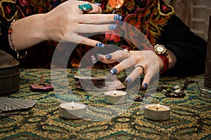 Gypsy psychic looking for a man in a photo using a pendulum. Love spell on photos photo