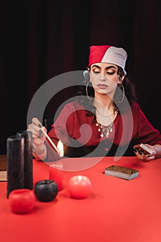 Gypsy soothsayer burring blurred candles and