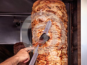 Gyros, doner. Man`s hands holding a knife, cutting slices