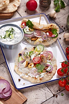 Gyros flatbread filled with chicken meat, tzatziki sauce and vegetables. photo