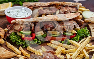 Gyros, shawarma, take away, street food. Sandwich with meat on wooden table photo