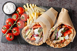 Gyros souvlaki wrapped in a pita bread closeup on the board. Horizontal top view