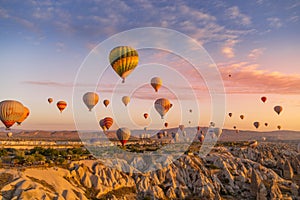 GÃÂ¶reme, Cappadocia, Turkey - October 7 2019:  Hot air balloons filled with tourists at sunrise floating along valleys of GÃÂ¶reme