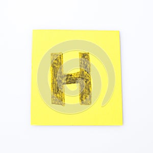 H alphabet letter handwrite on a yellow paper