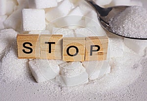 H pile of white sugar cubes and stop word in block letters as advise on addiction calories excess and sweet unhealthy food abuse c