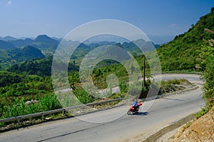 Ha Giang / Vietnam - 01/11/2017: Motorbiking backpackers on winding roads through valleys and karst mountain scenery in the North