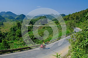 Ha Giang / Vietnam - 01/11/2017: Motorbiking backpackers on winding roads through valleys and karst mountain scenery in the North