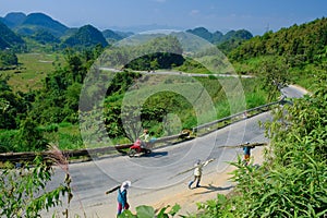 Ha Giang / Vietnam - 01/11/2017: Motorbiking backpackers on winding roads through valleys and karst mountain scenery in the North