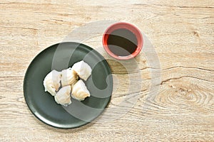 Ha Kao or white dumpling stuffed shrimp and pork on plate dipping soy sauce