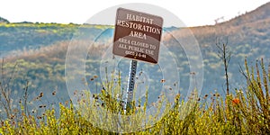 Habitat restoration area sign on a grassy mountain photo