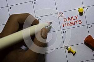 Daily Habits text on white calendar background. Reminder or schedule concept