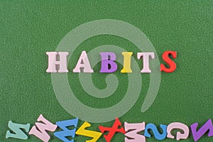HABITS word on green background composed from colorful abc alphabet block wooden letters, copy space for ad text. Learning english