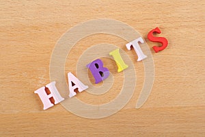 HABITS word on wooden background composed from colorful abc alphabet block wooden letters, copy space for ad text. Learning