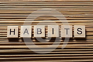 HABITS word written on wood abc block at wooden background