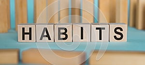 HABITS word written on wooden blocks on light blue background