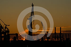 Habor cranes in front of a beautiful sunset in Hamburg