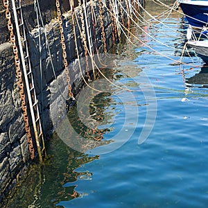 Habour wall with ropes chains and ladders for boats