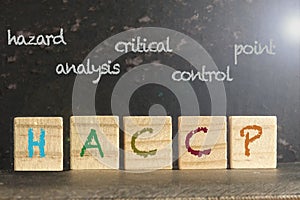 HACCP stamped on a wood scrabble pieces over a grunge black background