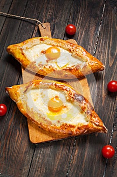 Hachapuri Adjara. Beautiful open pies khachapuri with egg on wooden