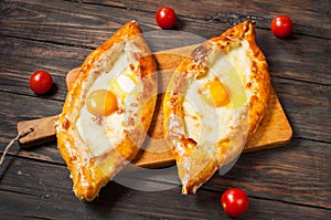 Hachapuri Adjara. Beautiful open pies khachapuri with egg on wooden