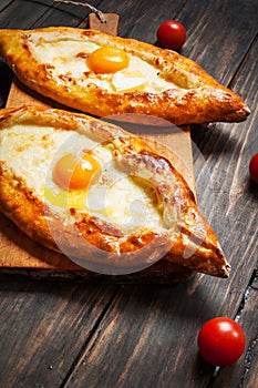 Hachapuri Adjara. Beautiful open pies khachapuri with egg on wooden