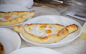 Hachapuri baked with egg yolk on a plastic plate