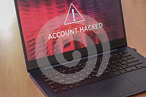 Hacked account concept on laptop screen with red background.