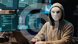Hacker with anonymous mask breaking security system