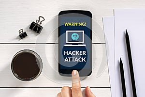 Hacker attack concept on smart phone screen with office objects