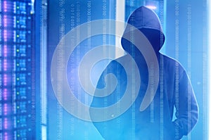 Hacker in black hoodie standing with binary code on virtual screen