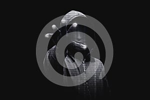 Hacker in black hoodie standing with open palms touch the digital binary code