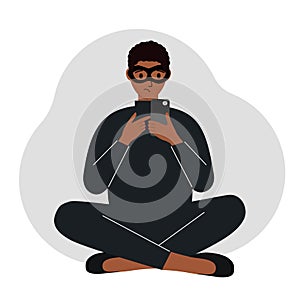 Hacker in a black mask with a mobile phone. The cybercriminal is holding a smartphone. Cyber attack, mobile phishing