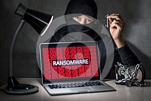 Hacker with computer screen showing ransomware attacking