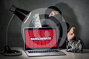 Hacker with computer screen showing ransomware attacking