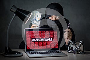 Hacker with computer screen showing ransomware attacking