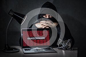 Hacker with computer screen showing ransomware attacking