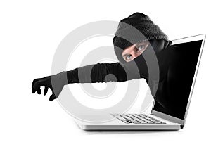 Hacker and cyber criminal man out computer screen with grabbing and stealing conceptual password hacking and cyber crime