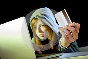 Hacker girl holding credit card violating privacy holding credit card in cybercrime and cyber crime