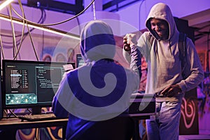 Hacker giving fist bump to crime partner