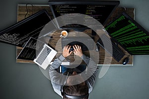 Hacker Hacking Multiple Computers On Desk
