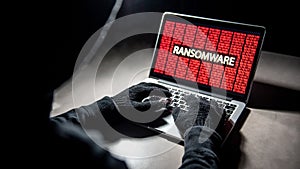 Hacker hand on laptop with ransomware attack screen