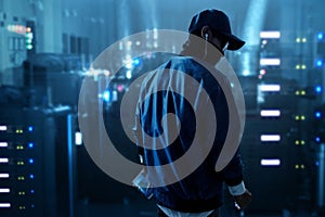 Hacker holding mobile phone in server room