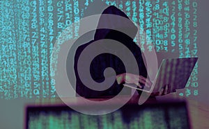 Hacker holding and using laptop over binary code digital background. Hacking the Internet