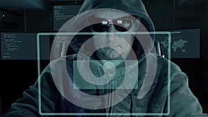 Hacker in hood and dark glasses sits in front of virtual screen and writes code for password decryption. Hacker get