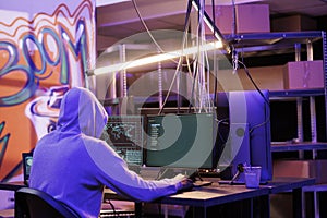 Hacker in hood running ransomware