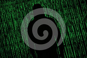 Hacker Internet security concept. Hacker silhouette on matrix background
