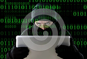 Hacker man in black using computer laptop for criminal activity hacking password and private information