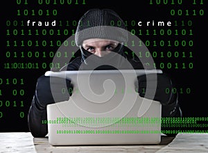 Hacker man in black using computer laptop for criminal activity hacking password and private information